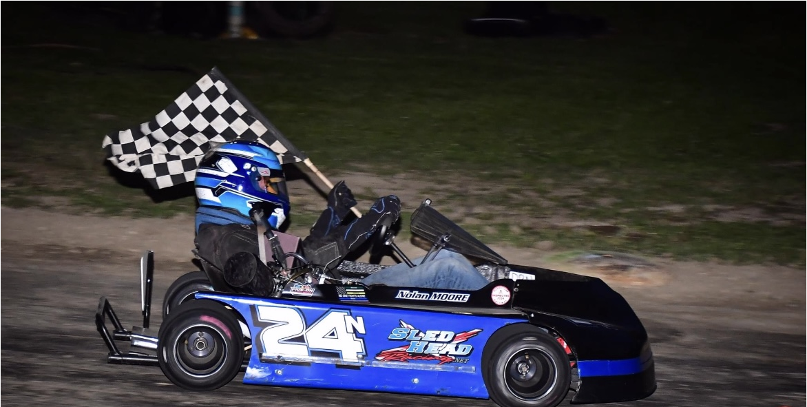 child in go kart waving finish flag
