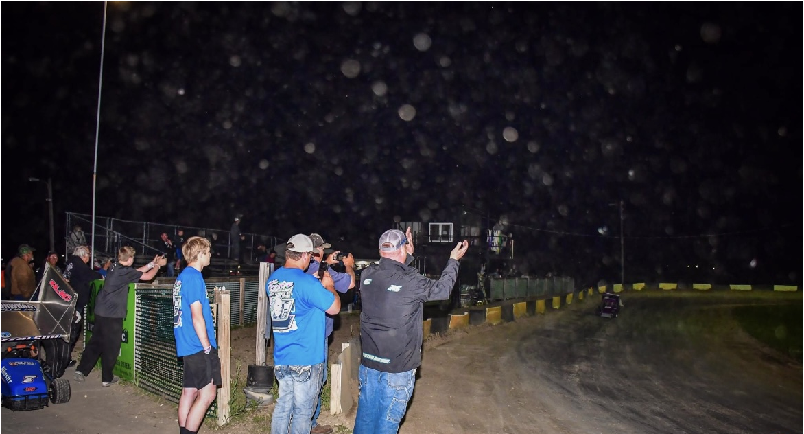 crowd cheering for the go karts at night