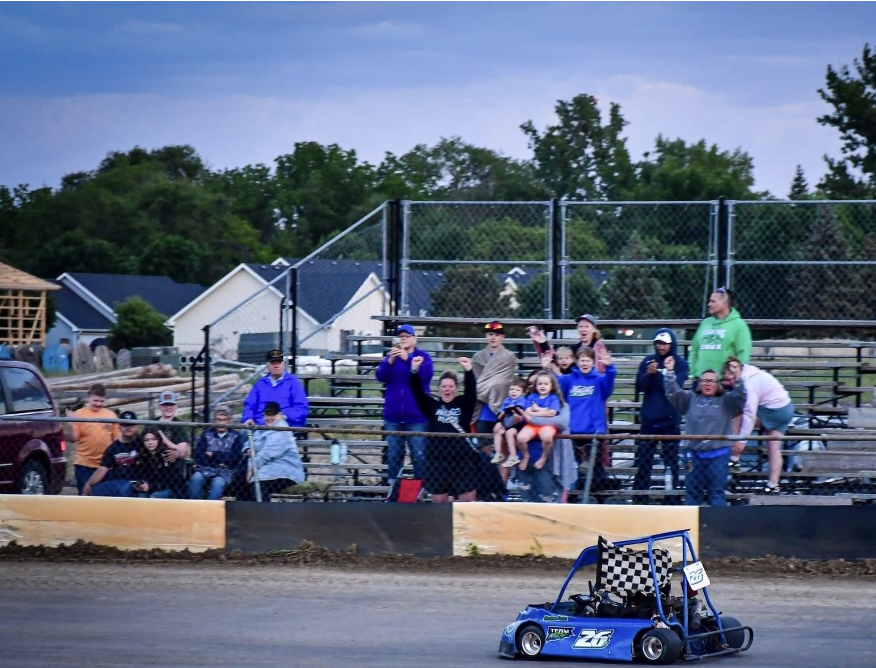 winner in go kart with checkered flag